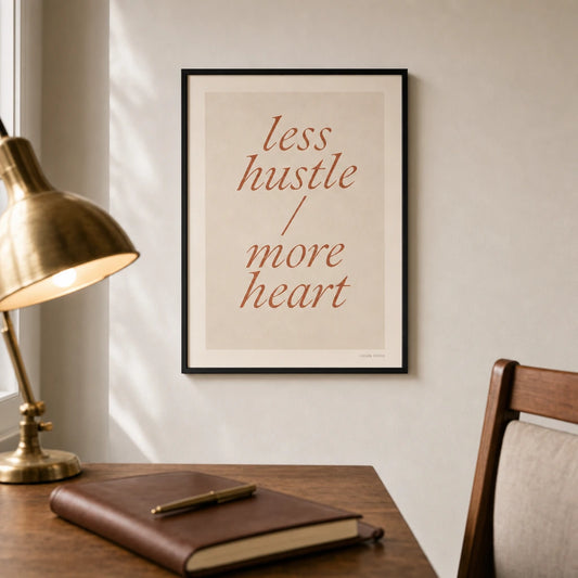 Less Hustle More Heart Poster — Two-line 'less hustle more heart' italic terracotta, lifestyle in interior, Atelier Poster