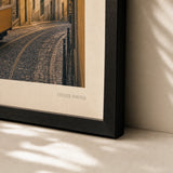 Lisbon Tram Hillside Poster — Vintage Lisbon yellow tram on cobblestone hill at sunset, close-up detail of print, Atelier Poster